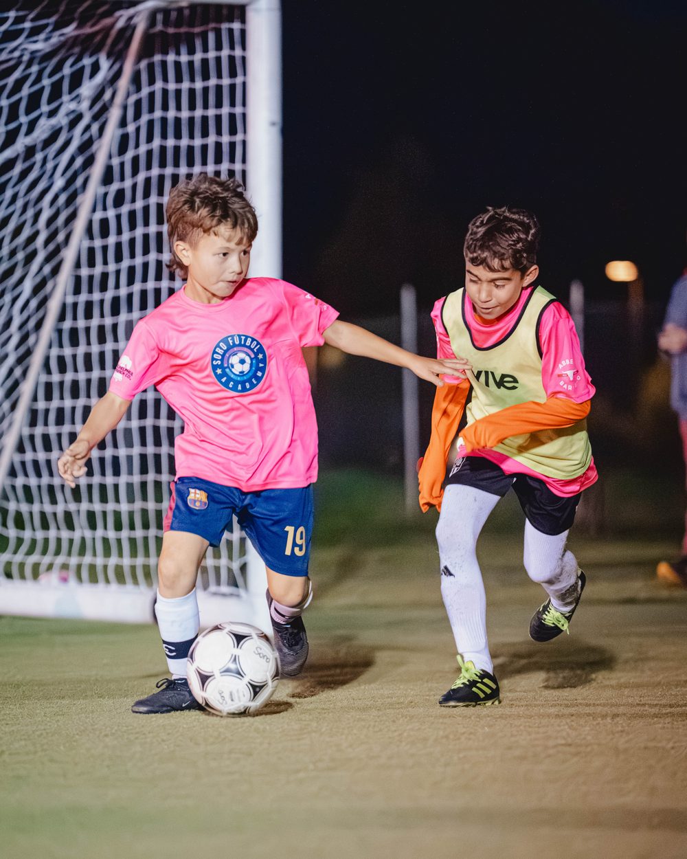 Soro Futbol Academy player in a pink jersey, night session