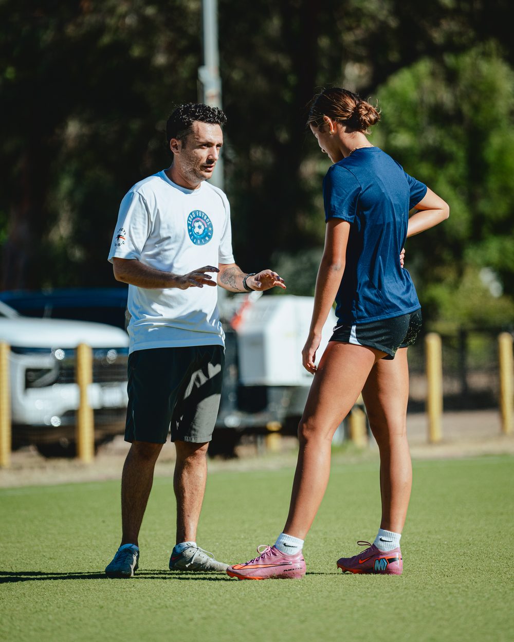 Coach Ray in a Soro Futbol Academy shirt coaching a player